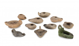 590.  Conjunto de 10 linternas de barro y una de cerámica vidriada en verde de época posterior.Trabajo romano, S. IV D. C..