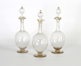 424.  Tres decantadores de cristal transparente y oro.Posiblemente Baccarat, S. XIX.