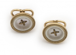 603.  Pareja de botones de pp s.XX en oro de 18K con círculos de nácar adornados con marco de cordoncillo y aspas centrales de oro simulando hilo.