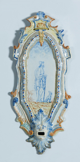 1037.  Placa en loza esmaltada, San Roque en el retablillo y un hombre hoja en relieve en la parte inferior.Alcora, S. XVIII
