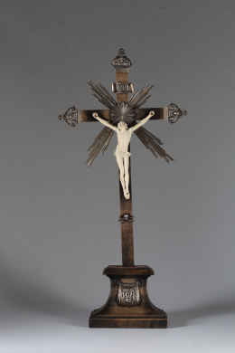 1196.  Cristo en marfil tallado.Sobre cruz de nogal patinado con cantoneras de plata con un querubín y hojasTrabajo europeo S. XVIII - XIX..