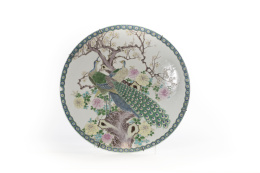 1062.  Plato en porcelana esmaltada con decoración de pavos reales, peonías y un almendro.China, S. XIX - XX