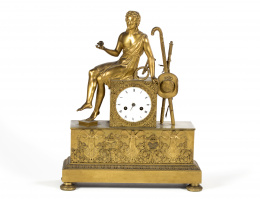 421.  Reloj de sobremesa de bronce dorado con figura sobre plinto, esfera esmaltada con numeración romana.Francia, primera mitad del S. XIX.