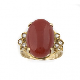 578.  Sortija con cabuchón de coral y tríos laterales de cabuchones de brillantes,en oro amarillo de 18K.