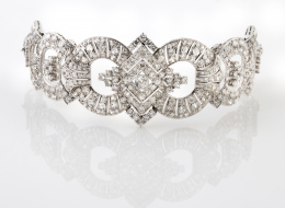 369.  Brazalete de platino y brillantes con centro Art-Decó de rombo y aros articulados. De estructura semirígida facilmente adaptable como diadema o collar choker