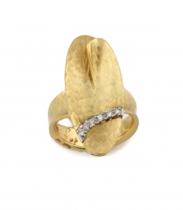 706.  Sortija con gran óvalo frontal adornado con curva de brillantes,realizada en oro martelé de 19K.