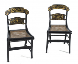 467.  Pareja de sillas regencia en madera ebonizada con decoración polícroma dorada en el respaldo y asientos de rejillaInglaterra primer cuarto del siglo XIX.