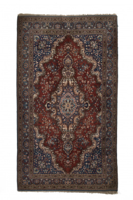 546.  Alfombra en lana con campo rojo y cartucho central, S. XX..