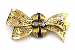 772.  Broche lazo años 50 con centro de brillantes y zafiros sintéticos calibrados y decoración calada.
