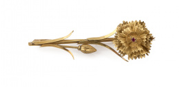 67.  Broche con diseño de clavel en oro amarillo de 18K con rubí central