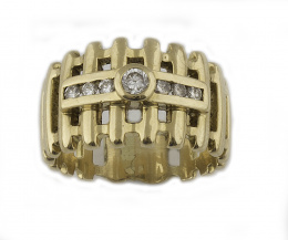 98.  Sortija ancha con brillantes en chatón y banda central, en montura de barras caladas de oro amarillo de 18K.