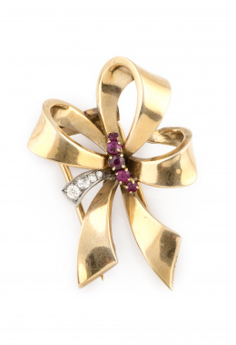 196.  Broche clip lazo años 40 con banda de brillantes y rubíes en oro de 18K