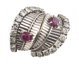 503.  Sortija tipo chevalière años 60 con frente ancho formado por dos hojas perfiladas por brillantes y adornadas cada una por un rubí de talla oval
