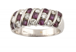 189.  Sortija con rubíes y brillantes en damero que componen banda frontal en oro blanco de 18K.