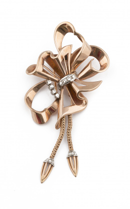 710.  Broche lazo años 40 con varias cintas entrelazadas y caladas ; adornadas con bandas de brillantes y borlas colgantes, en oro rosa de 18K