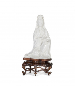 1020.  Guanyin en porcelana blanc du Chine, sobre base de madera tallada.China, S. XX