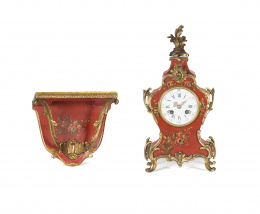 1010.  Reloj estilo Luis XV  lacado en rojo con aplicaciones en bronce dorado sobre ménsula S. XX.