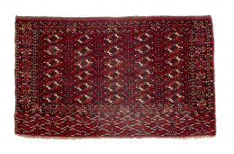 451.  Alfombra en lana de la tribu de los Tekke, con diseño geométrico sobre campo rojo.Turquemenistán, ffs. del S. XIX - pp. del S. XX..