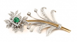376.  Broche flor con esmeralda central de 0,80 ct aprox e intenso color, rodeada por pétalos de brillantes, tallo con hojas de diamantes y brillantes