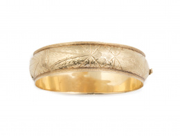 124.  Brazalete de media caña grabado en oro amarillo de 18K