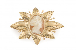 119.  Broche con camafeo de dama tallado en concha bicolor  en marco con hojas caladas entre varillas a modo de estambres