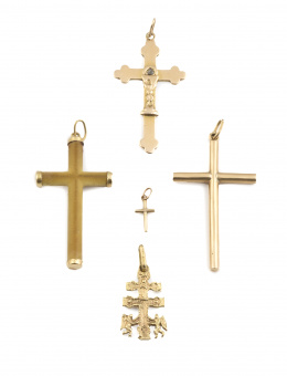 136.  Lote formado por cuatro crucifijos y una cruz de Caravaca  colgantes en oro amarillo de 18K
