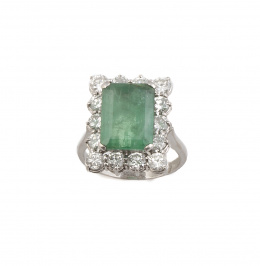 243.  Sortija con esmeralda central de talla rectangular rodeada por orla de catorce brillantes que suman 2,7 ct aprox.