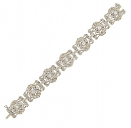 169.  Brazalete de platino y brillantes años 50, con siete centros de motivos florales con centro de brillante, rodeados de diamantes,y articulados por bandas dediamantes