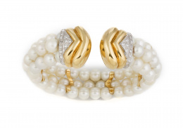 218.  Brazalete flexible con tres hilos de perlas cultivadas y remates de brillantes en oro bicolor gallonado de 18K.