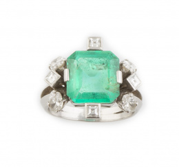 332.  Sortija años 50 con es,meralda de 4,25 ct aprox.de intenso color, adornada en la montutra con diamantes talla carré y navette