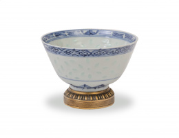 648.  Cuenco de porcelana  "grano de arroz" esmaltada en azul y blanco, y montada en bronce. Con marcas en la base en azul cobalto bajo cubierta.China, S. XIX.
