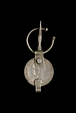 100.  Lote formado por trece fíbulas con monedas