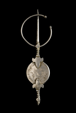 102.  Lote formado por doce fíbulas con monedas 