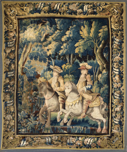653.  Tapiz en lana con dos caballeros en un paisaje, y cenefa de flores y cintas.Trabajo franco-flamenco, S. XVII.