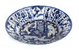 492.  Plato en porcelana Kraak decorada en azul con personajes, el ala con objetos y flores en reservas.China, Wanli, S. XVII.