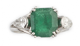 682.  Sortija con esmeralda de 1,30 ct aprox, flanqueada por dos diamantes talla perilla en montura de platino