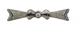 121.  Broche lazo Art-Decó con brillante de talla antigua central de 0,35 ct aprox, con zafiros calibrados y diamantes