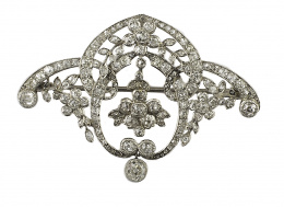 134.  Broche Belle époque de brillantes de talla antigua,con diseño de guirnaldas en que rodean flores con chatón de brillante central colgante