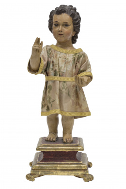 1221.  “Niño Jesús como Salvator Mundi” Escultura de bulto redondo en madera tallada y policromada, sobre base en madera tallada, estofada y dorada. España, S. XVIII.