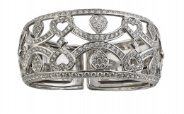 443.  Brazalete de brillantes ancho calado y ligeramente bombée, con diseño de ondas, corazones y gotas de pavé de brillantes, entre dos líneas en riviére que flanquean el contorno