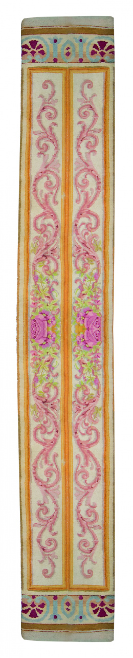 1204.  Alfombra española de pasillo en lana con decoración de roleos en rosa, pp. del S. XX.