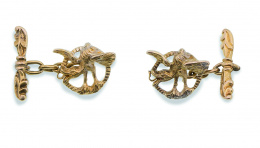 74.  Gemelos de pp. S. XX con figuras de dragón que dibujan círculo, unidas por sistema de cadena a barra labrada con formas vegetales