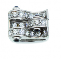 619.  Sortija estilo chevaliere con bandas curvas entrelazadas de brillantes, flanqueadas por cabuchones de zafiros 