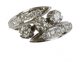 609.  Sortija con trío de brillantes engastados en garras entre brazos abiertos de brillantes 