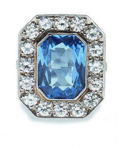 663.  Sortija con topacio azul de talla rectangular en marco octogonal de brillantes