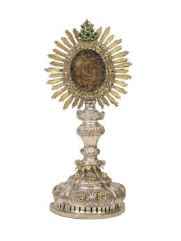 1068.  Relicario en forma de custodia de tipo de las de sol, con la Vera Cruz y otras reliquias de plata en su color y plata dorada, con decoración grabada y de aplicación de piedras simuladas en cabujón.España, S. XVIII.