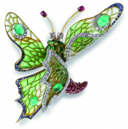 754.  Broche mariposa de diseño asimétrico, con alas de esmalte Plique-à-jour adornadas con cabuchones de esmeraldas rodeados de brillantes y perfil de zafiros y brillantes
