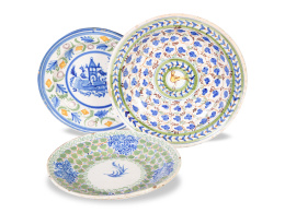 702.  Lote de tres platos de cerámica esmaltada, uno con pajarito y otro con arquitecturas.Dos de Manises y uno de Onda, S. XIX.