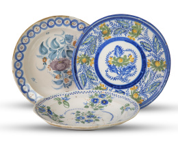 711.  Juego de tres platos de cerámica esmaltada con decoración floral.Manises, S. XIX.