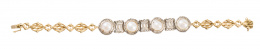 110.  Pulsera de pp. S. XX con cuatro centros de perlas orlados de diamantes, separados por piezas de bandas arqueadas de diamantes 